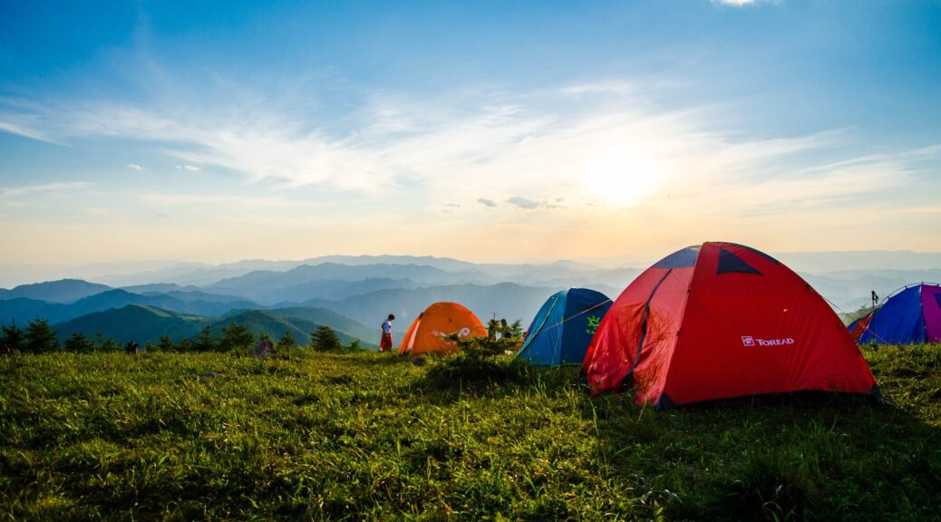 photo of pitched dome tents overlooking mountain ranges